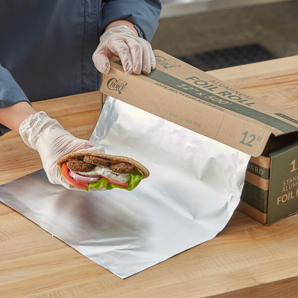 A person in gloves holding a sandwich wrapped in EcoChoice recycled aluminum foil.