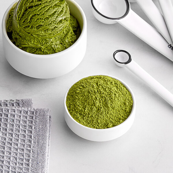 A bowl of Jade Leaf green matcha powder next to a whisk.