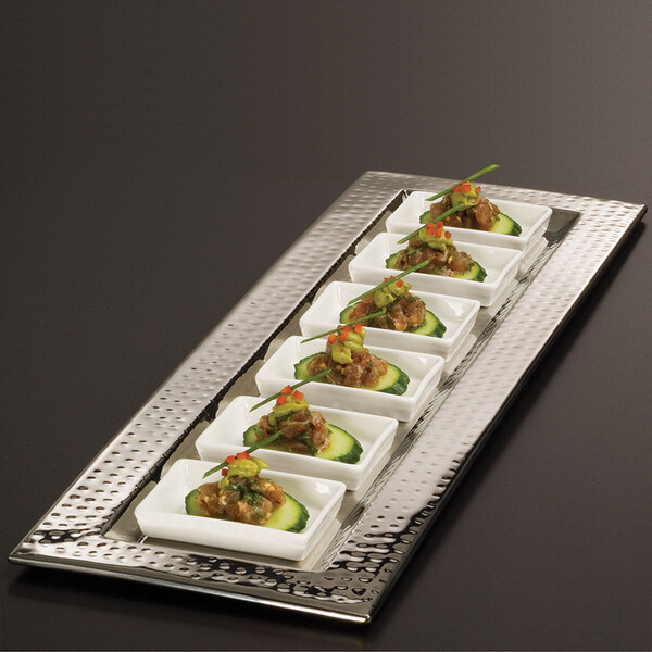 An American Metalcraft rectangle hammered stainless steel tray holding six dishes of food on a table.