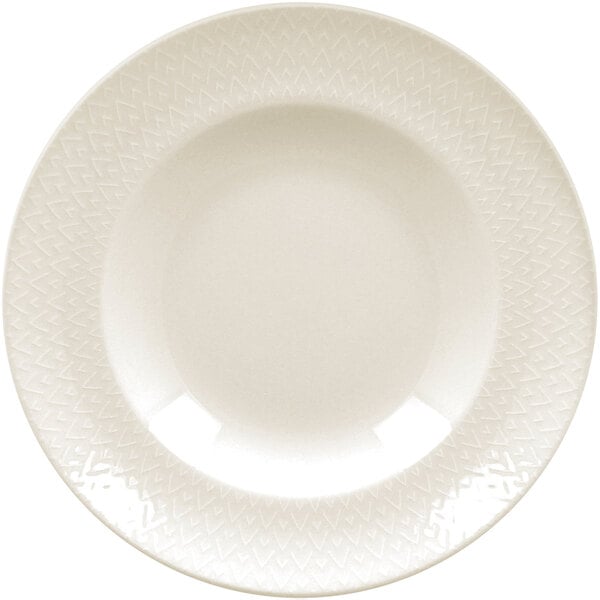 A close up of a RAK Porcelain ivory flat plate with an embossed circular pattern.