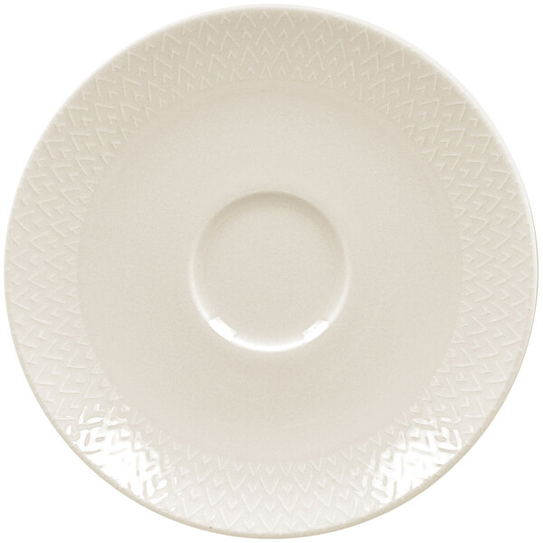A close up of a RAK Porcelain ivory saucer with a circular edge and pattern.