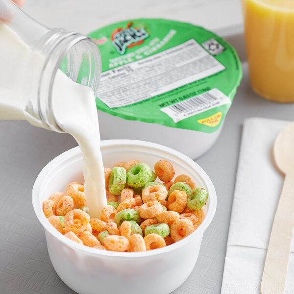 A bowl of Kellogg's Apple Jacks cereal with milk being poured into it.