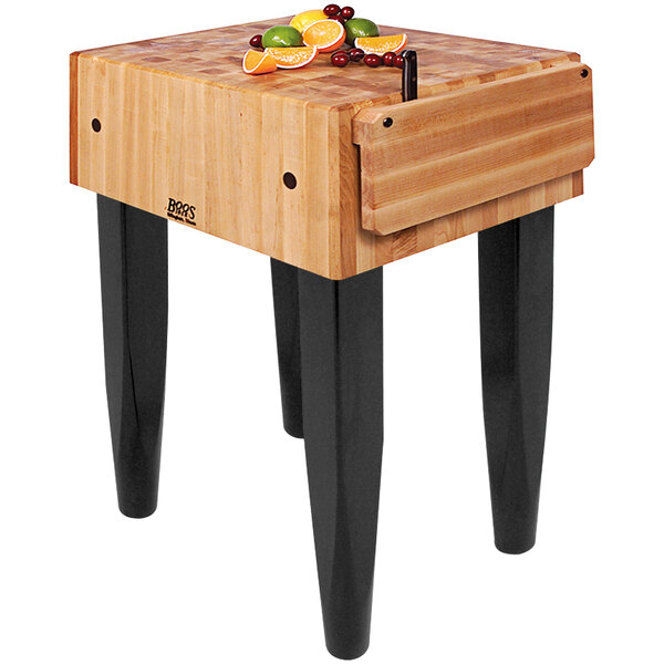 A John Boos maple butcher block table with a knife on it.