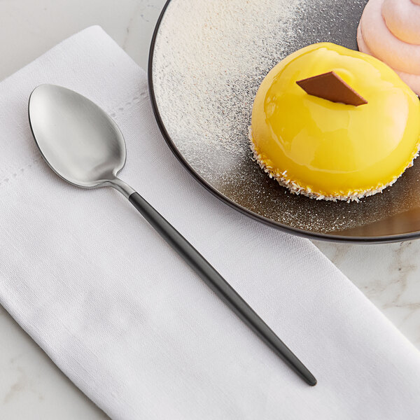 An Acopa Odin stainless steel teaspoon on a plate with dessert.