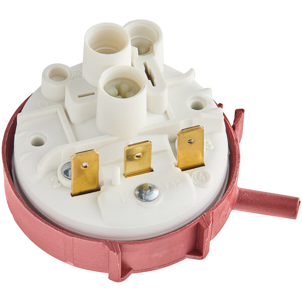 A round white and red pressure switch with gold metal connectors.