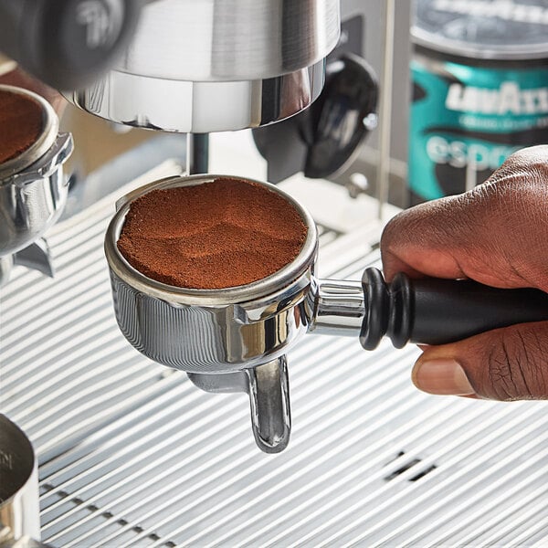 A hand using a coffee machine to brew Lavazza Decaf Espresso Italiano.