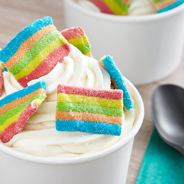 A cup of ice cream with Vidal Mini Sour Gummy Rainbow Belts on top.