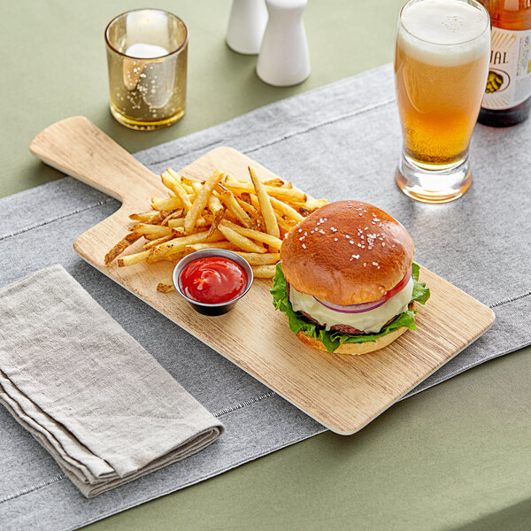An Acopa faux wood melamine serving board with a burger and fries on a table.