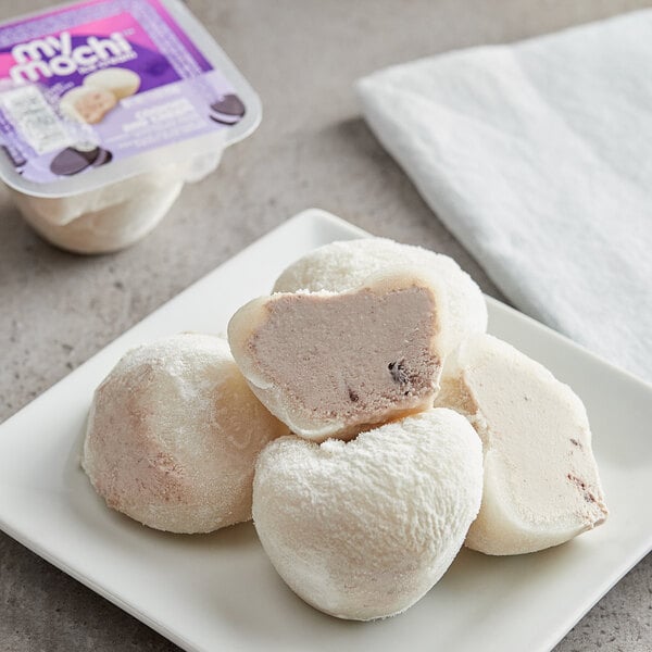 A plate with two heart-shaped cookies and cream mochi ice cream.