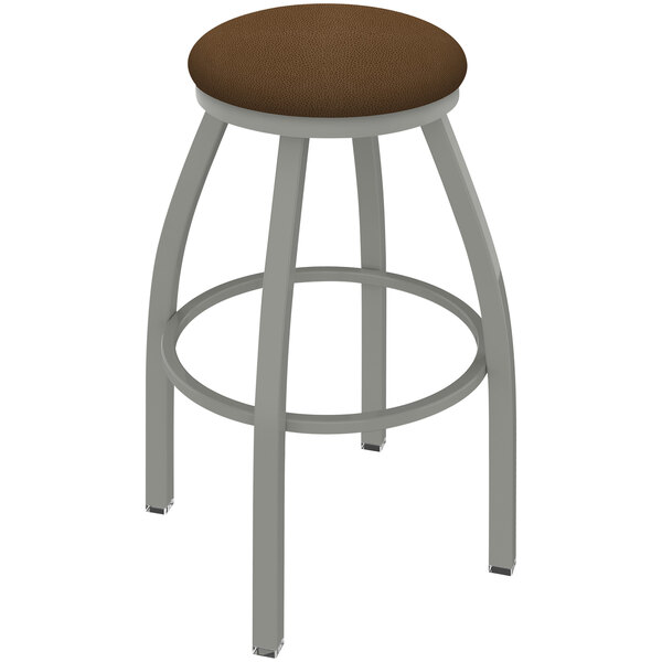 A Holland Bar Stool Misha Ladderback Swivel Bar Stool with a Rein Thatch Seat and Anodized Nickel Finish with a brown seat.