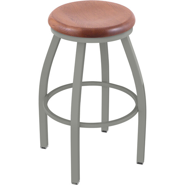 A Holland Bar Stool ladderback swivel bar stool with a wooden seat.