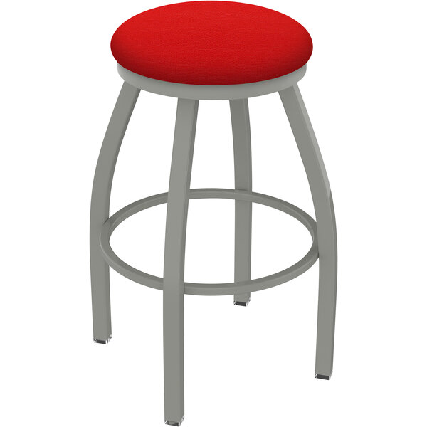 A Holland Bar Stool Misha Ladderback Swivel Bar Stool with a red seat and metal legs.