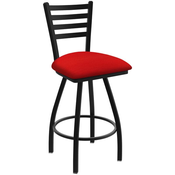 A black Holland Bar Stool ladderback swivel bar stool with a red cushion.