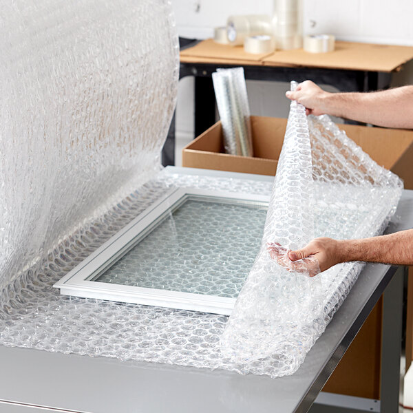 A person holding a roll of Pregis large bubble wrap.