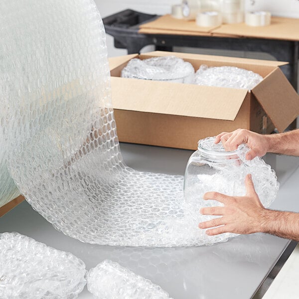 A person holding a clear jar of Pregis bubble wrap.