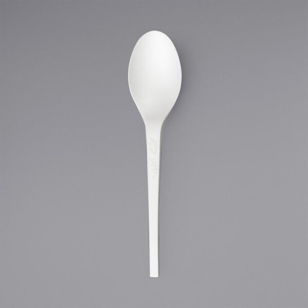 A close up of a white Solia plastic spoon.
