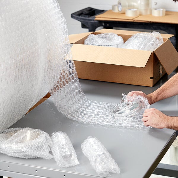 A person packing Pregis bubble wrap on a table.