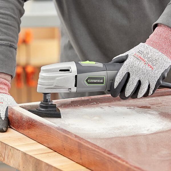 A person using a Genesis oscillating tool to sand a piece of wood.