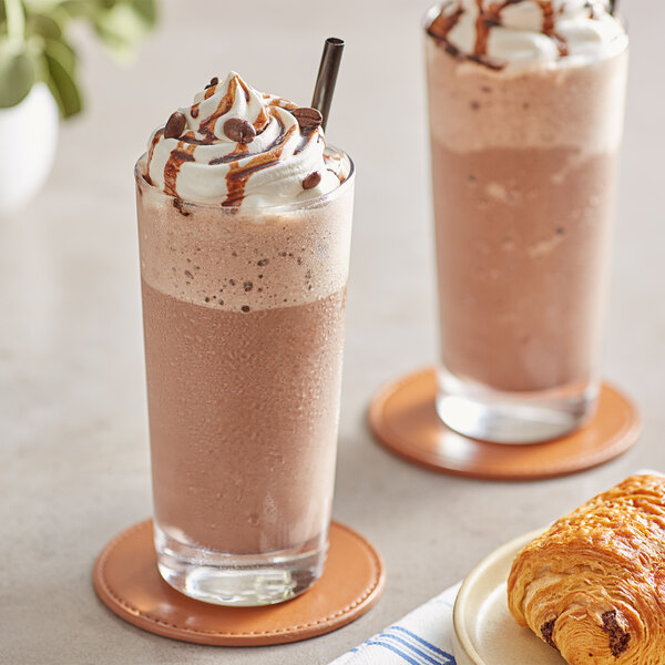 Two glasses of Frozen Bean Mocha Latte blended ice coffee with whipped cream and croissants.