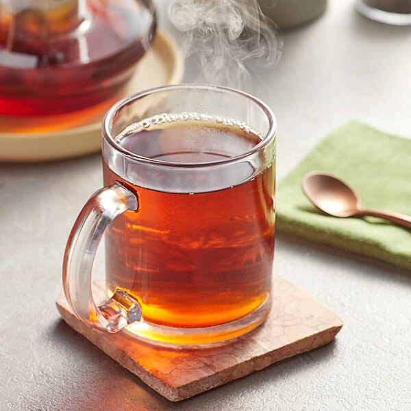 A glass mug of brown Davidson's Organic Decaf English Breakfast tea on a table.