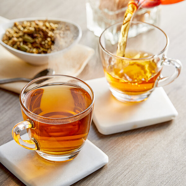 A glass cup of Davidson's Organic Classic Chai Herbal Tea with brown liquid.