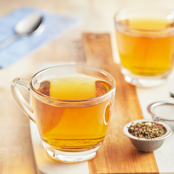 A glass mug of Davidson's Organic Spicy Mint Herbal tea with spices.