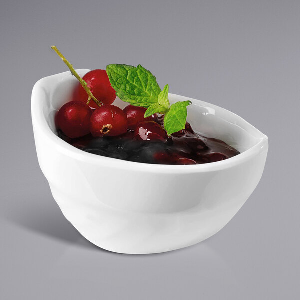 A white APS melamine bowl filled with cherries and mint leaves.