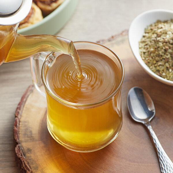 Davidson's Organic Mezclado de Mate Herbal tea being poured into a glass cup.