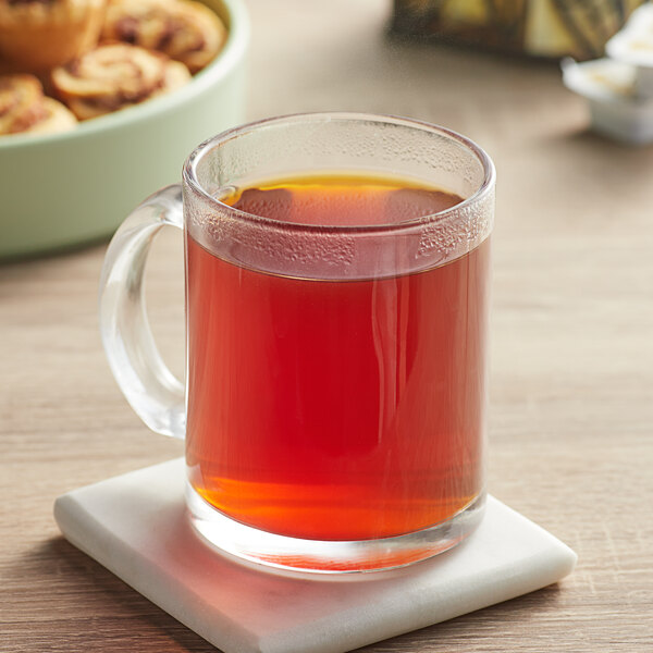 A glass mug of Davidson's Organic Lemon Essence with Peel tea on a coaster.