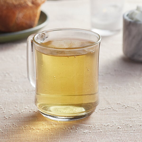 A glass mug of Davidson's Organic Formosa Style Oolong tea on a table.