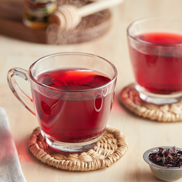 A glass of Davidson's Organic Hibiscus Tea with red liquid.