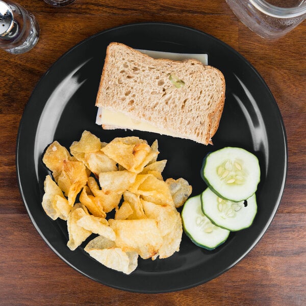 A Carlisle black melamine plate with a sandwich 