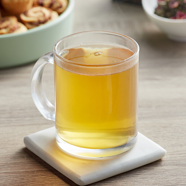 A glass mug of Davidson's Organic Jasmine Rose tea on a white coaster.