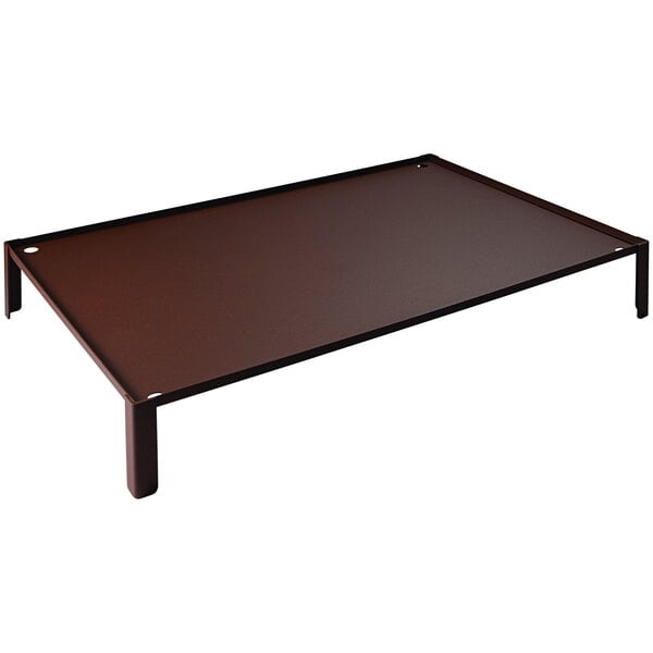 A brown metal tray with metal legs on a brown rectangular table.
