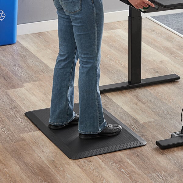 A person standing on a black 360 Office Furniture anti-fatigue mat.