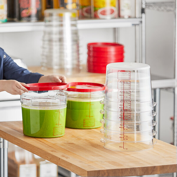 A person holding a Vigor food storage container of green liquid with a red lid.