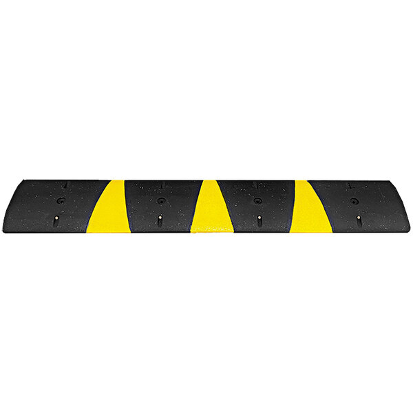 A black rubber speed bump with yellow reflective stripes and cat eye reflectors.