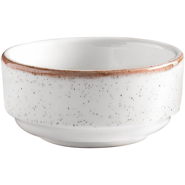 A beige porcelain bowl with brown specks on the rim.
