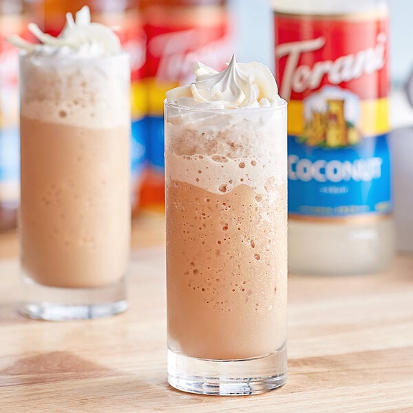 Two glasses of iced coffee with whipped cream and Torani Coconut syrup.