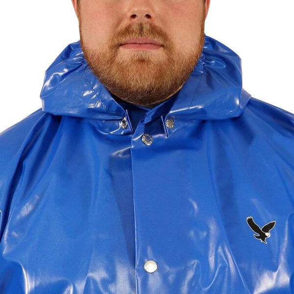 A man wearing a blue Tingley raincoat with a black eagle on it.