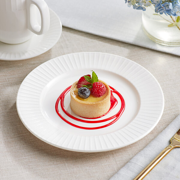 An Acopa Cordelia bright white porcelain plate with a dessert topped with berries.