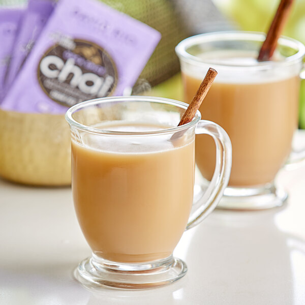 Two glass mugs of David Rio Orca Spice sugar-free chai tea latte with cinnamon sticks.