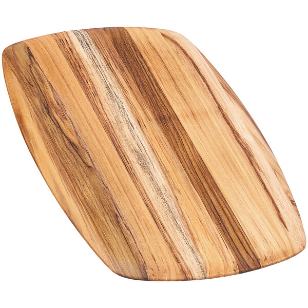 A Teakhaus teakwood serving board with a rounded edge on a table.