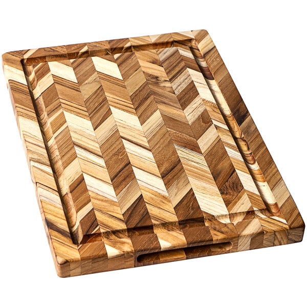 A Teakhaus edge grain teakwood cutting board with a herringbone pattern on it.