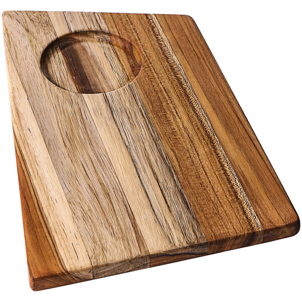 A Teakhaus teakwood cutting board with a bowl insert in the middle.