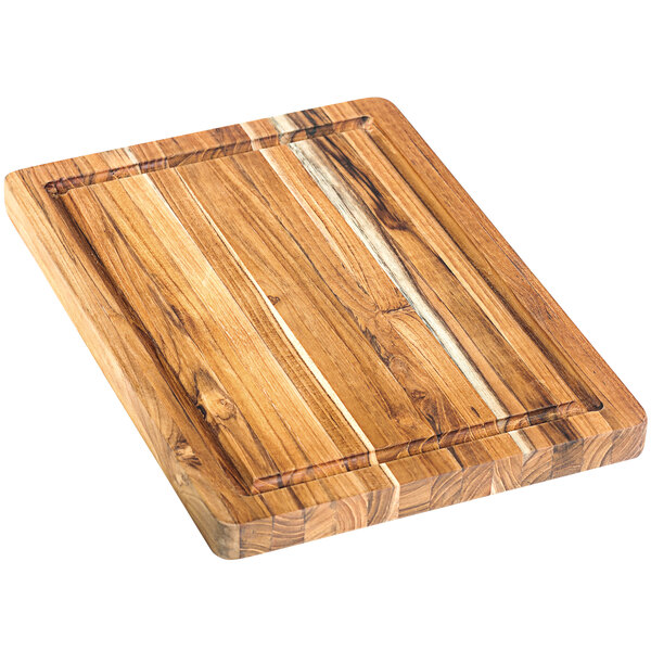 A Teakhaus end grain teakwood cutting board with hand grips.