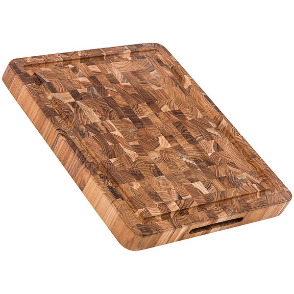 A Teakhaus end grain teakwood cutting board with hand grips.