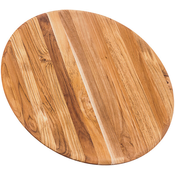 A Teakhaus round teakwood serving board with a rounded edge on a table.