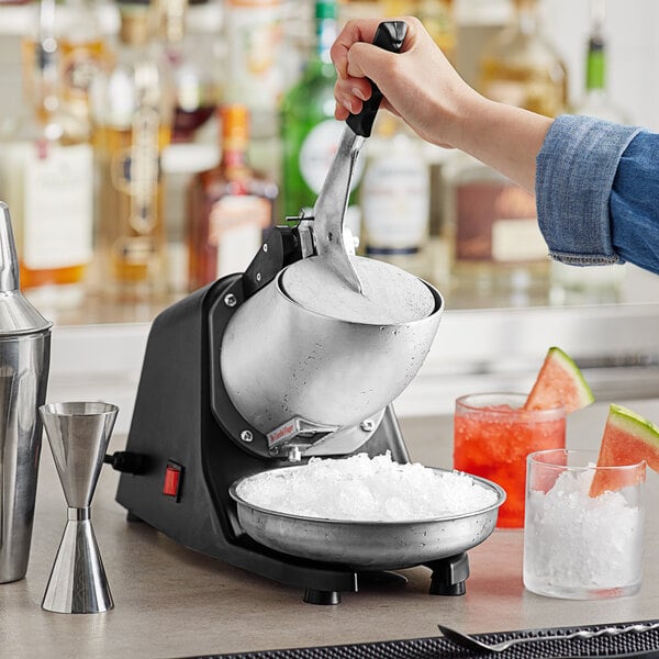 A person pouring ice into the Galaxy CTIC300 Countertop Ice Crusher.