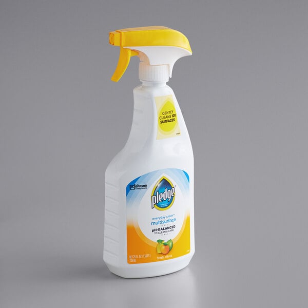A white spray bottle of SC Johnson Pledge Multisurface Cleaner with a yellow cap.